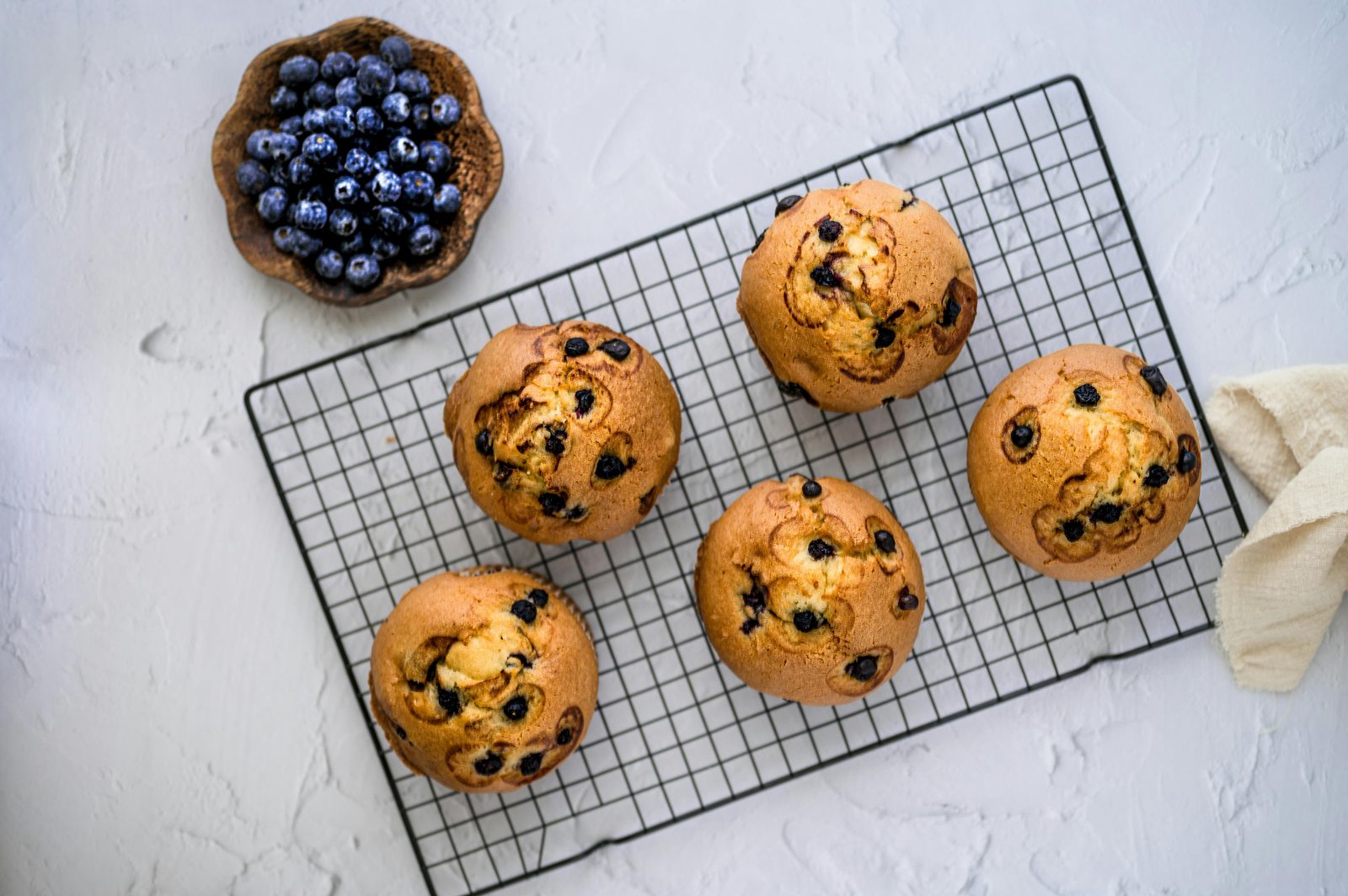 A tray of golden-domed blueberry muffins fresh from the oven