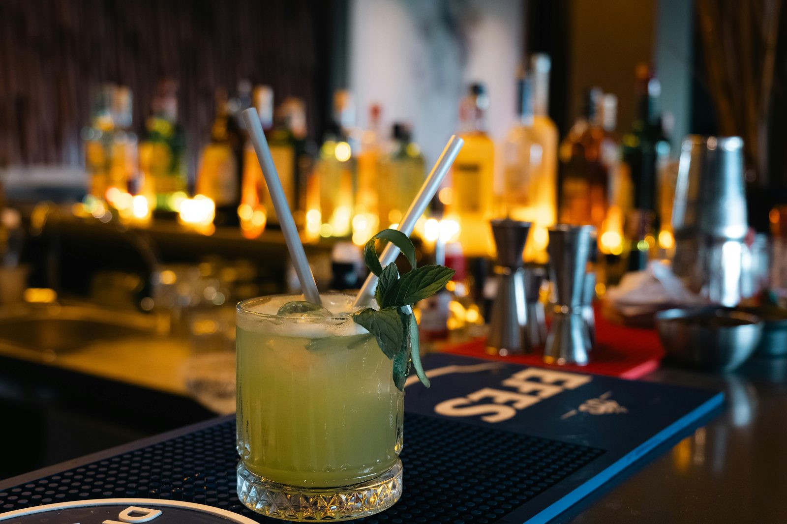 A warmly lit bar at night with amber glasses