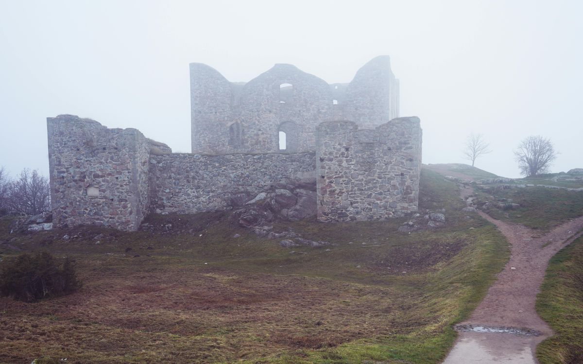 A ruined stone castle shrouded in fog